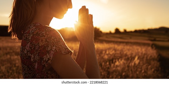 Religious Worship, And Spiritual Enlightenment Concept. Woman Saying A Prayer A Sunset. 
