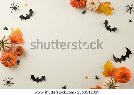 Relishing the distinct fascination awakened by the enchantment of Halloween. Top view of colorful pumpkins, autumn leaves, spooky decor on light grey background with advertising space