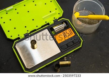Reloading 45 acp pistol caliber cartridges, scales for weighing gunpowder, cartridges.