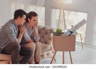 Rely On Me. Displeased Upset Young Woman Sitting On Sofa And Propping Her Head With Hand While Her Careful Boyfriend Hugging And Calming Her Down