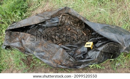 Remains of a decomposed human body in a black sanitary body bag.