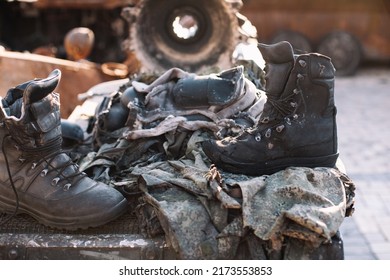 Remains Of Russian Soldiers. Burned Russian Military Uniform Lying On Destroyed Russian Armored Military Vehicle.