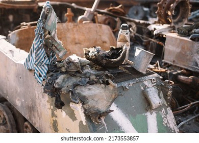 Remains Of Russian Soldiers. Burned Russian Military Uniform Lying On Destroyed Russian Armored Military Vehicle.