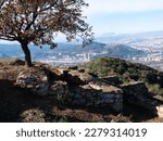 Remains of stone structures of ancient Iberian settlement on top of mount Puig Castellar in Catalan municipality of Castellar del Valles on sunny day, Spain