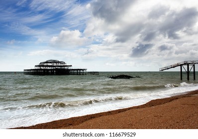 Remains of west pier, with waves crashing on shore, Brighton, England, UK