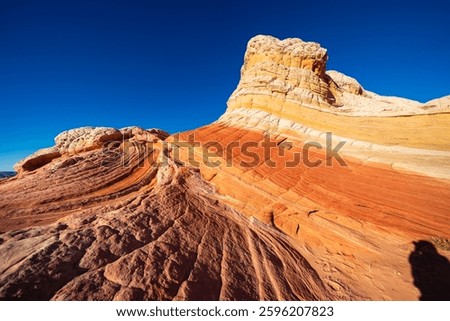 Remarkable sandstone formations rise dramatically against a clear blue sky at White Pocket in the Vermilion Cliffs National Monument, Arizona USA.