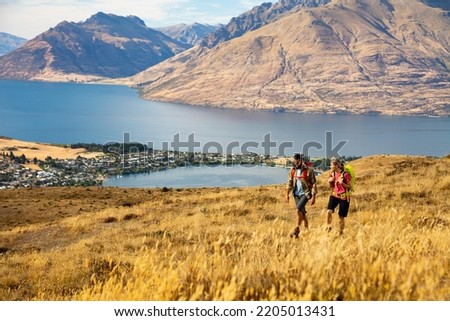 The Remarkables young Caucasian couple with backpacks extreme trekking to keep fit outdoors near Lake Wakatipu Otago New Zealand