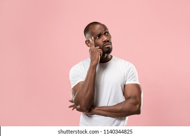 Remember all. Let me think. Doubt concept. Doubtful, thoughtful afro man remembering something. Young emotional man. Human emotions, facial expression concept. Studio. Isolated on trendy pink. Front