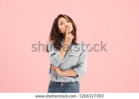 Remember all. Let me think. Doubt concept. Doubtful, thoughtful woman remembering something. Young emotional woman. Human emotions, facial expression concept. Studio. Isolated on trendy pink