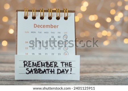 Remember Sabbath Day, handwritten quote with calendar on wood with bokeh background. Christian holy time rest, obedience, and worship God Jesus Christ
