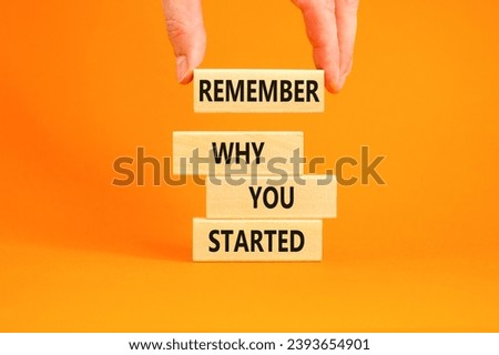 Remember why you started symbol. Concept word Remember why you started on wooden block. Beautiful orange table background. Businessman hand. Business remember why you started concept. Copy space.