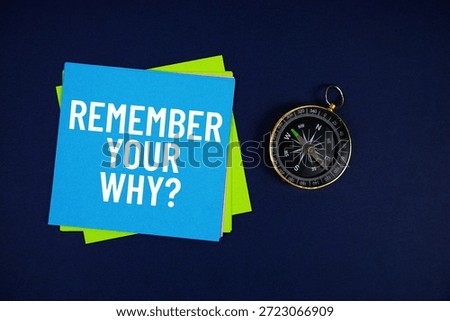 Remember Your Why? text written on sticky note with compass on blue  background