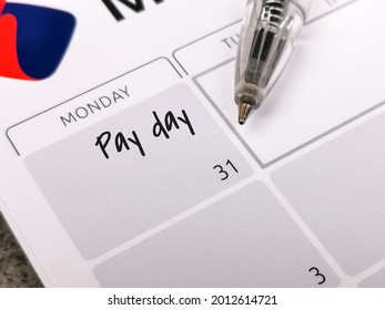 Reminder Concept Of Payment. Close Up Text Pay Day Written On Calendar With A Pen. Selective Focus.