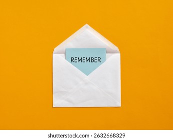 Reminder note in white envelope on vibrant orange background, conveying a message of remembering important dates or tasks