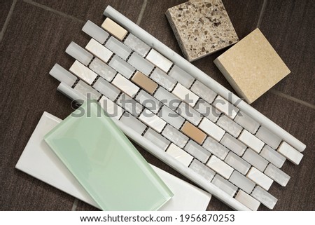 remnants for bathroom remodel includes glass tile backsplash countertop samples and mosaic tile accent with bullnose trim against porcelain tile floor