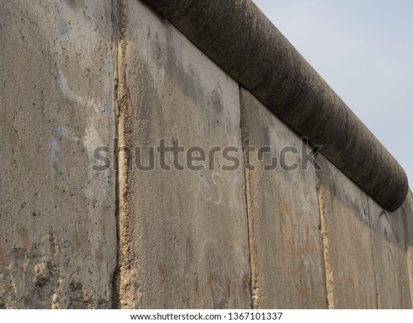 Remnants of the\
Berlin wall. The Berlin Wall was a guarded concrete barrier that\
divided Berlin from 1961 to\
1989.