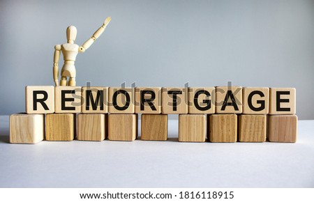 'Remorgage' written on wood blocks. Business concept. Wooden model of human. Copy space. Beautiful white background.