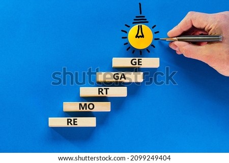 Remortgage loan symbol. Wooden blocks with the word Remortgage. Light bulb icon. Businessman hand with pen. Beautiful blue background, copy space. Business, remortgage loan concept.
