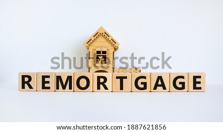 Remortgage symbol. Wooden cubes form the word 'remortgage' near miniature house. Beautiful white background, copy space. Business and remortgage concept.