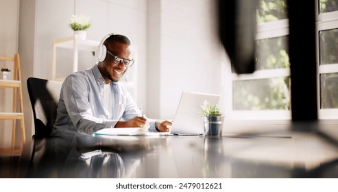 Remote African-American Marketer Thrives in Virtual Training Sessions and Webinars at Home Office Using Smart Laptop - Powered by Shutterstock