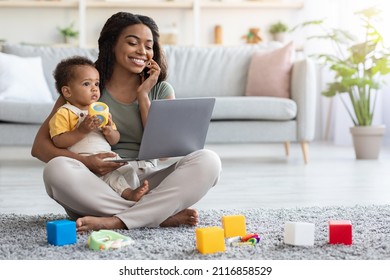 Remote Business. Portrait Of Happy Black Woman With Baby Working With Laptop And Cellphone At Home, Busy Young African American Lady Using Laptop And Mobile Phone For Online Work, Copy Space