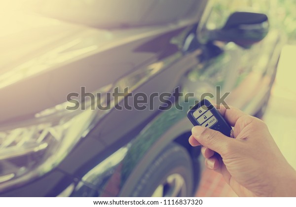 Remote car key with\
black car background.