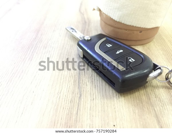 Remote car key on wood\
table.