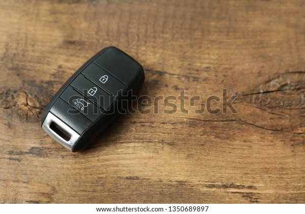 Remote car\
key on wooden background. Space for\
text
