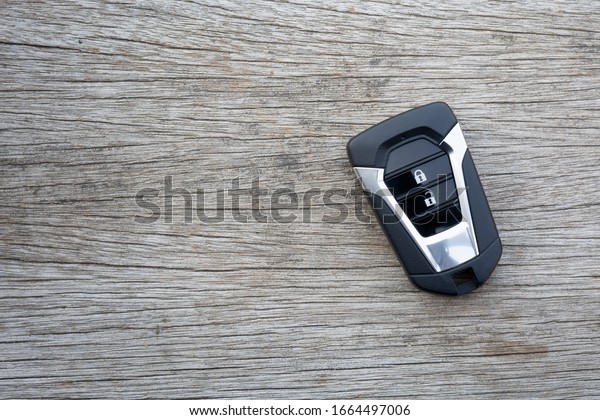 Remote car key\
placed on old wooden\
floors.