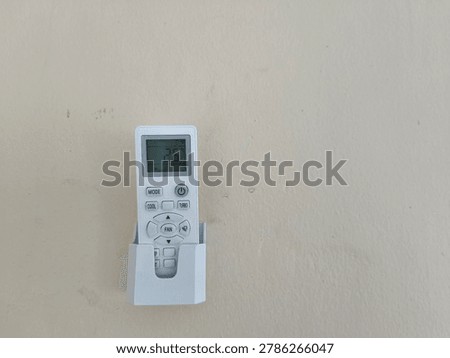 Remote control for air conditioner in wall holder