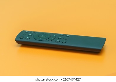 remote control black from the TV on an orange background - Shutterstock ID 2107474427