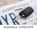 Remote control car keys on Pennsylvania license plate with driver license. Concept of driving in Pennsylvania. Reaching a driving permit