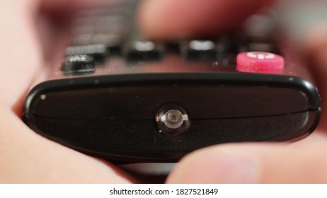 remote control close-up front view. man holding an electronic device and pressing buttons and switching channels of tv. close up