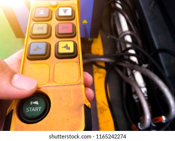 Remote Control Crane For Factory Industrial Yellow Remote And Green Keypad The Start Button Is Green. And Orange Light Down The Side. And Side Blurred. Abstract Concept.