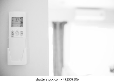 remote control hang on the wall and air conditioner blur background.Black and white tone.