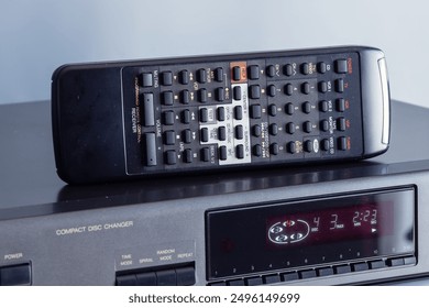 Remote Control on the Top of the Compact Disc Player, Multi Disc Changer, Stereo Gear from 90's, Angled View