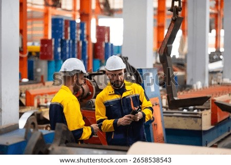 remote control overhead crane : engineer worker working control sheet metal roof machine at metal sheet profiling factory. Industrial production. Service and Maintenance of factory machinery