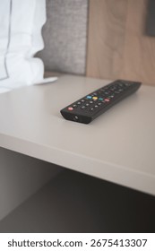 Remote control placed on a bedside table in a room