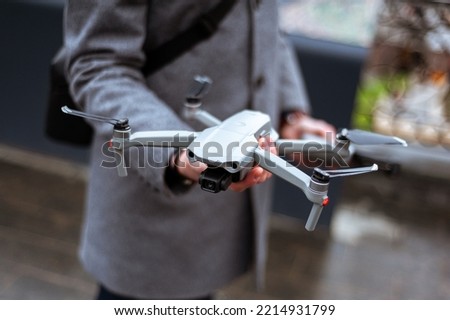 Remote control of the quadcopter. The operator controls the drone. The phone on the remote control. Quadrotor filming. Fingers on the joystick control