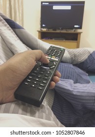 Remote control television select bottom use by man comfortable in everyday life.