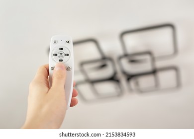 Remote control that controls the light. Neon chandelier on the ceiling.