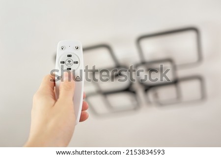 Remote control that controls the light. Neon chandelier on the ceiling.