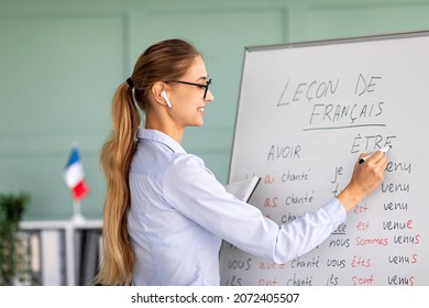 Remote Education And Tutoring Concept. Female Teacher Writing Grammar Rules On Whiteboard During Online French Lesson, Happy Tutor Teaching Foreign Language On Web