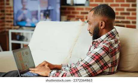 Remote employee using online analytics statistical data charts to identify trends and predict business outcomes. while working from home. Teleworker monitorizing market key performance indicators