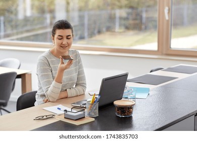 remote job, business and people concept - smiling young woman with smartphone and laptop computer using voice command recorder on smartphone at home office - Powered by Shutterstock