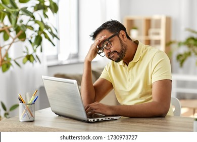 Remote Job, Technology And People Concept - Bored Or Sad Young Indian Man In Glasses With Laptop Computer Working At Home Office