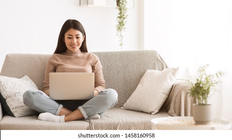 Remote Job. Teen Girl Working On Laptop, Sitting On Sofa Comfortably, Free Space