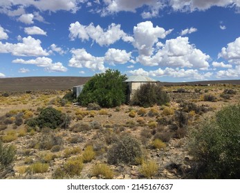 Remote Karoo farm with a kraal near Sutherland, under a blue sky with clouds.