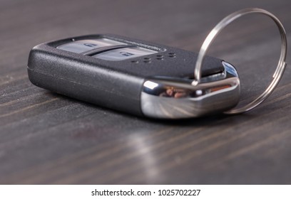 Remote Keyless Car Key On Wooden Table Top.