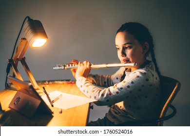 Remote Music Lesson. Girl Playing The Flute At Home At The Night.